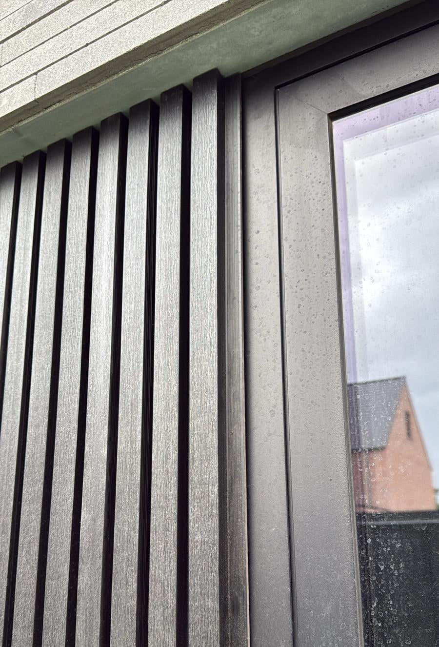  Zwarte composiet gevelbekleding naast een deur